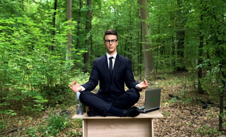 Picture of a man sitting on a table in the forest.